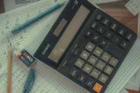 a calculator sitting on top of a pile of papers